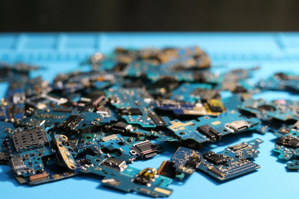 Mano che tiene un cacciavite per riparare un dispositivo elettronico