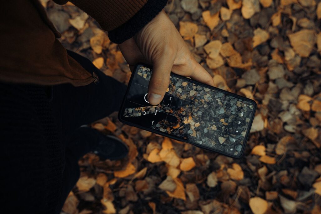 Persona che scatta una foto con un moderno smartphone con teleobiettivi, rappresentando il miglior smartphone per fotografia nel 2026.