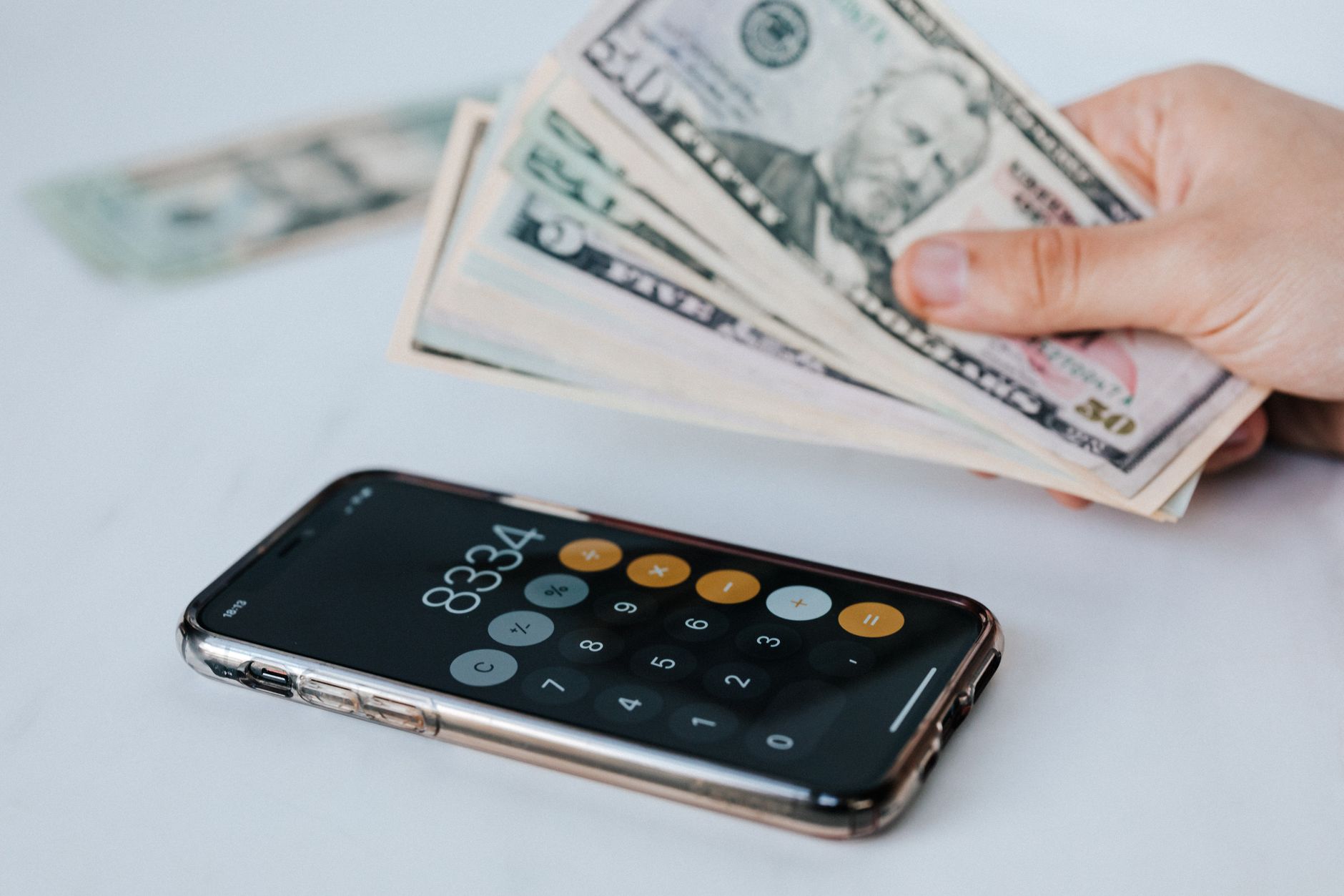 Mano che confronta diversi modelli di smartphone moderni per scegliere il migliore rapporto qualità prezzo nel 2026.