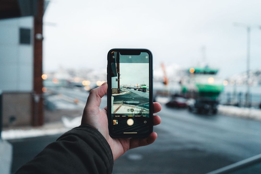 Mano che mostra uno smartphone usato sul bancone per la valutazione del trade-in