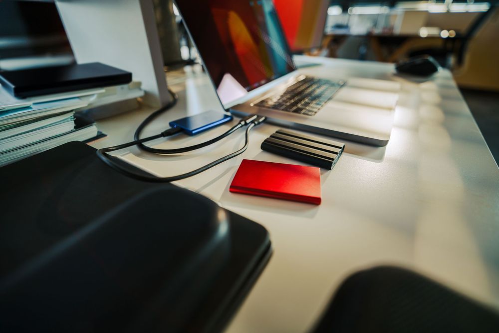 Tecnico che installa un SSD in un laptop su una scrivania, mostrando il vecchio HDD accanto al nuovo SSD per evidenziare il miglioramento.